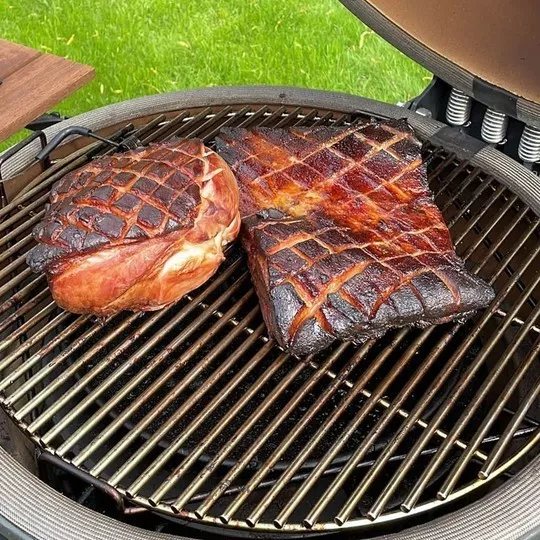 Workshop bbq Het Belvershuys: grote stukken vlees op de Kamado klaarmaken.